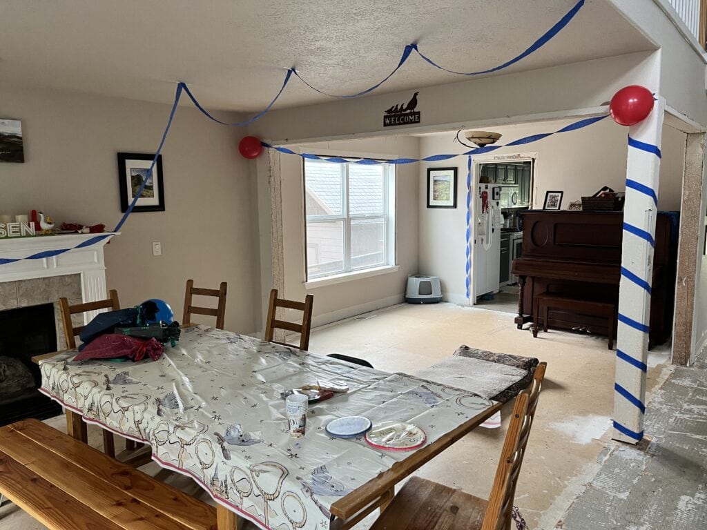 dining room decorated with streamers, balloons and presents on table