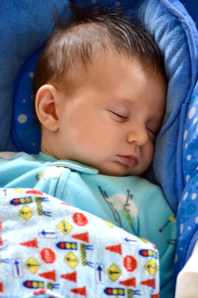 Our baby sleeping in a blue baby bouncy chair