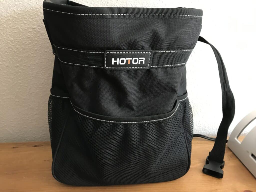 Black HOTOR trash can on table.