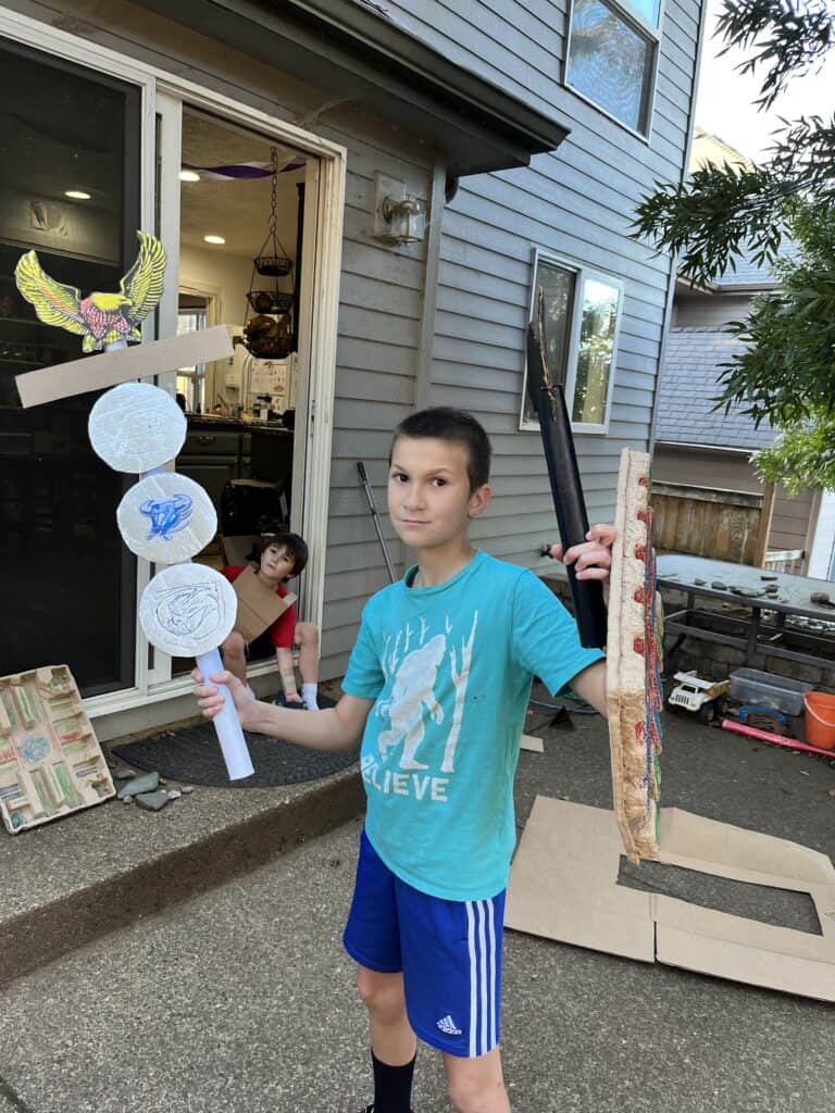 Our son holding his cardboard Roman military standard and shield