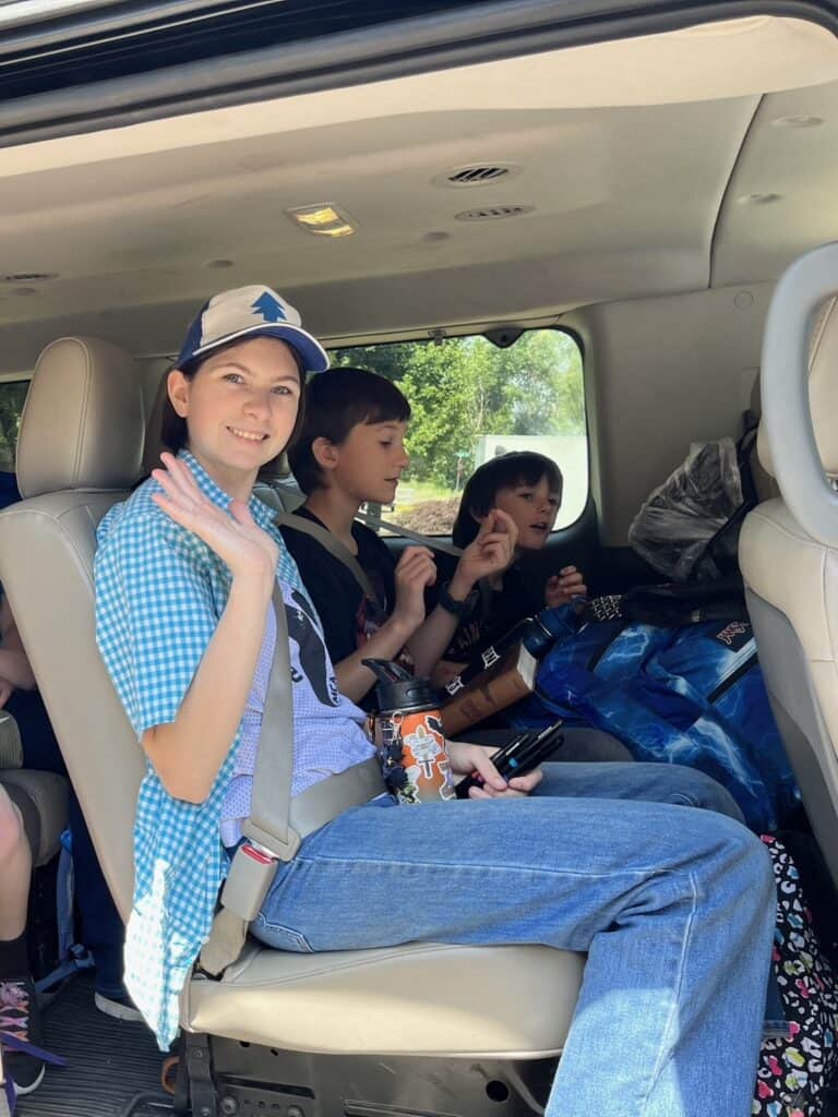 Kids and teens in vehicle before road trip.