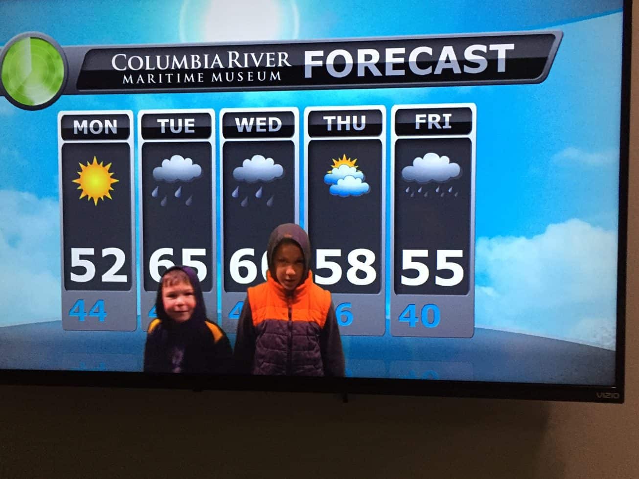 Kids pretending to be meteorologists in the weather forecast exhibit at the Columbia River Maritime Museum in Astoria, Oregon.