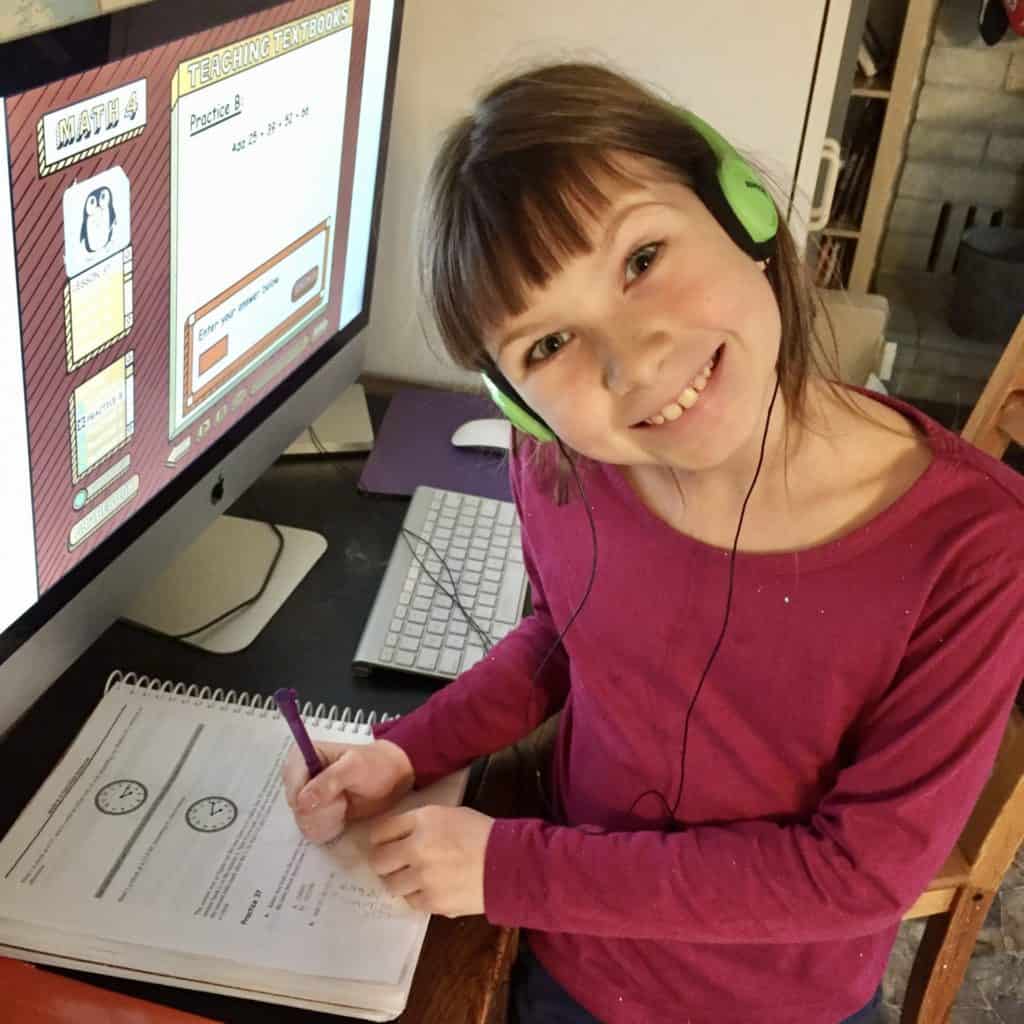 girl working on computer with headphones