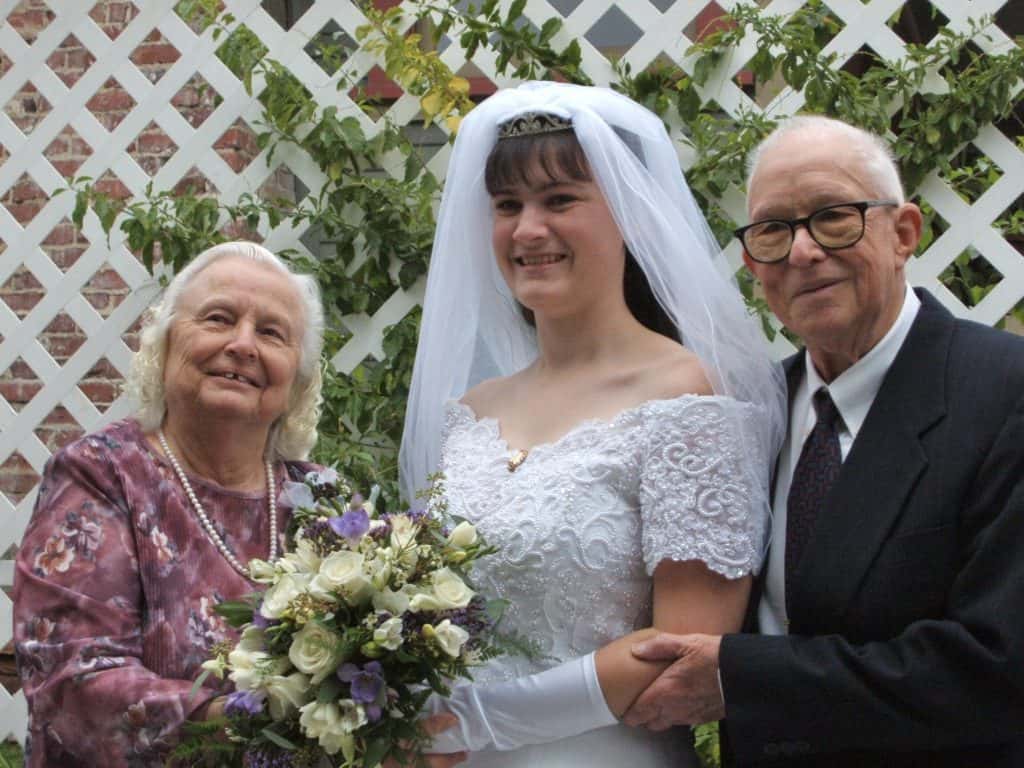 Woman with grandparents on wedding day.