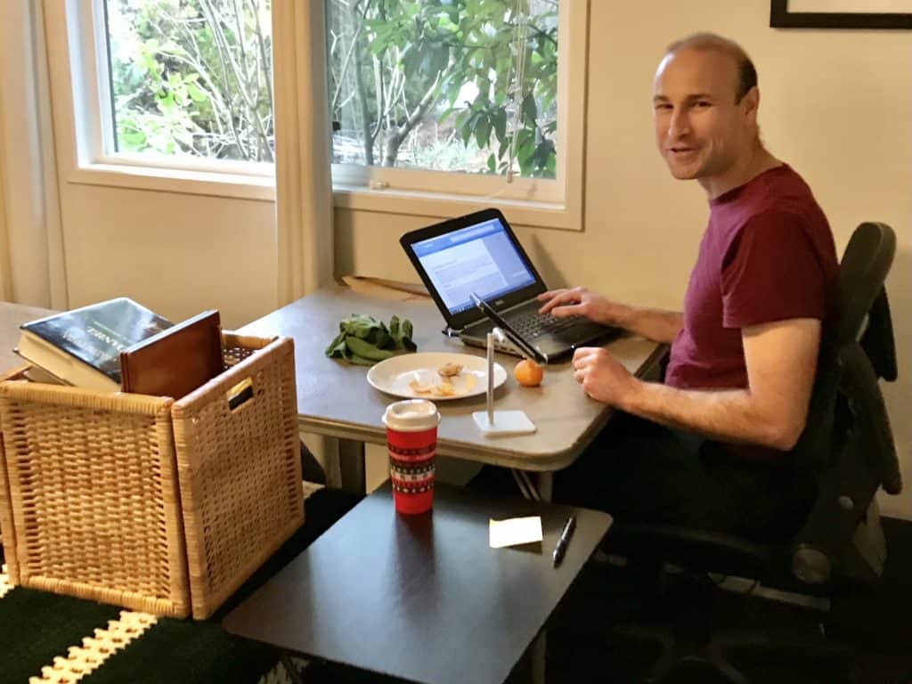 Man eating lunch in a makeshift bedroom office during the pandemic. Adult ADHD made it a struggle to stay organized and finish projects on time for Brian. 