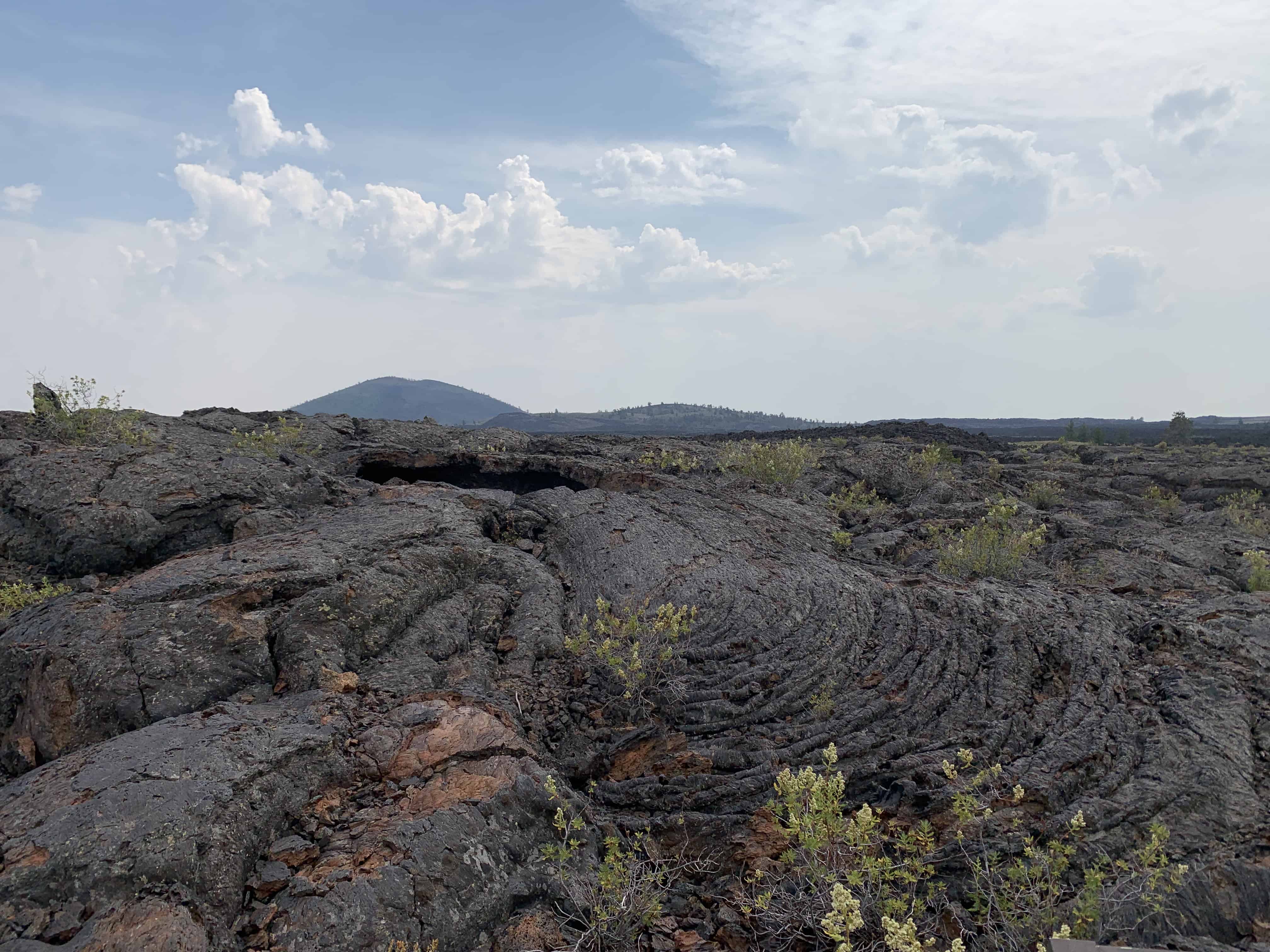 lava field with mountains in background. Craters of the Moon NM has so many volcanic features!