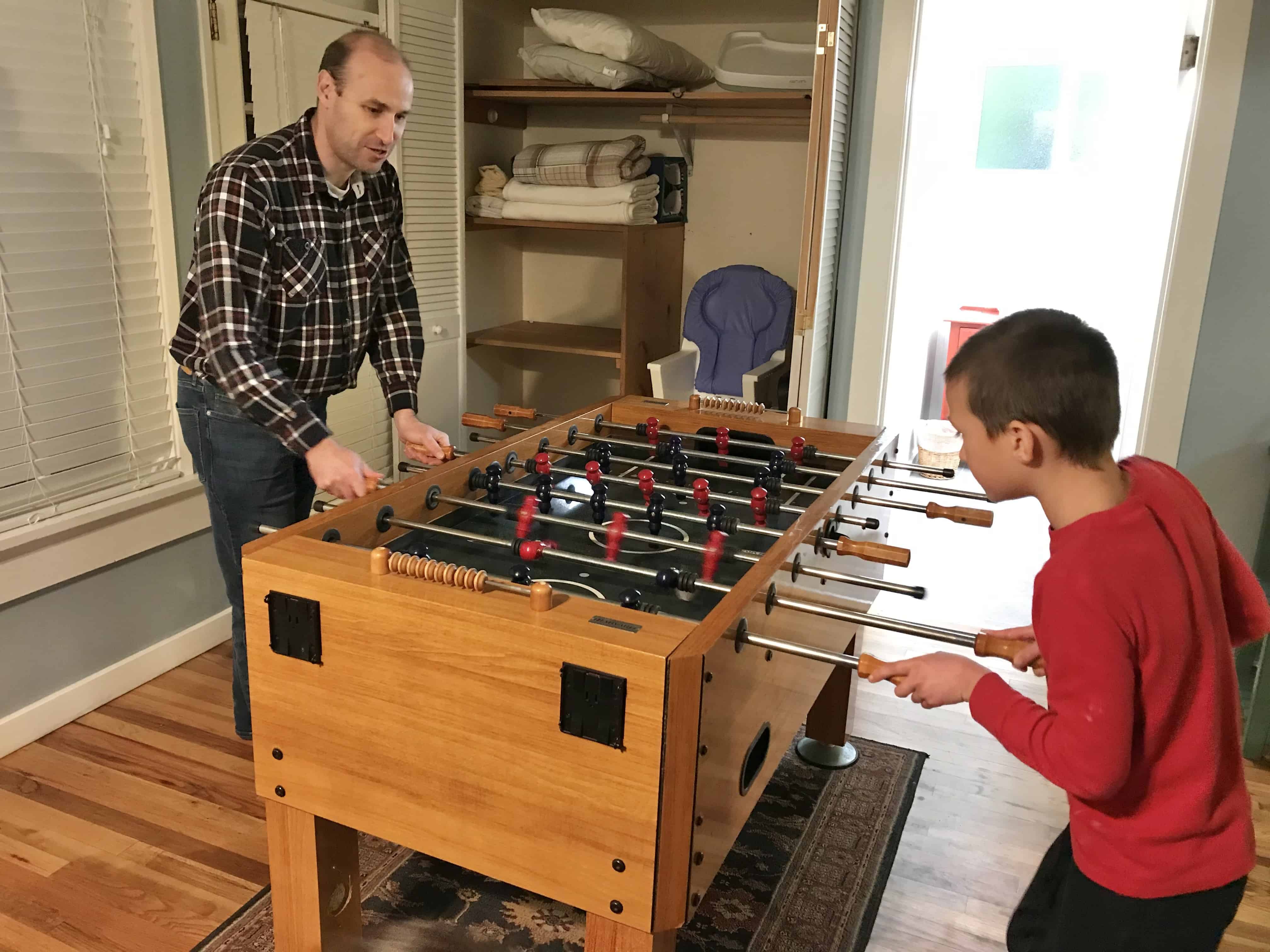 Man and boy playing foosball