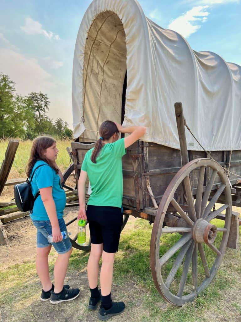 Two of our daughters look inside a covered wagon at the Whitman Mission NHS.