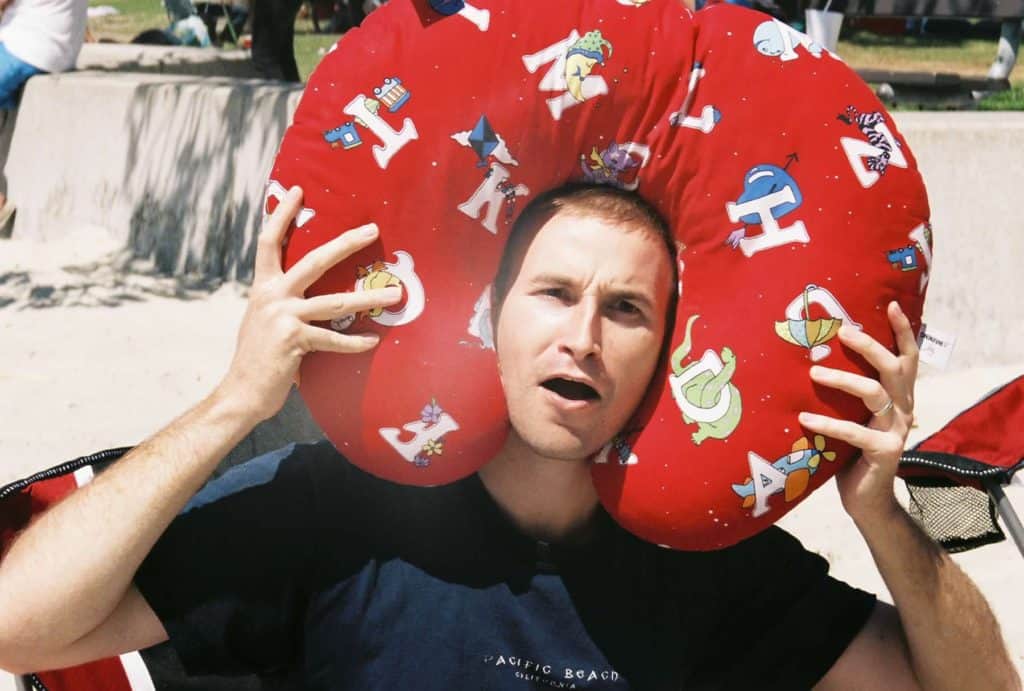 Man with Boppy pillow around head and silly face.