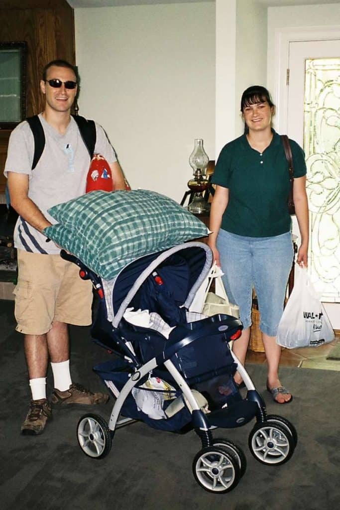 Husband and wife with baby stroller and arms full of baby gear. A baby registry often contains lots of handy items, as well as many unnecessary ones.