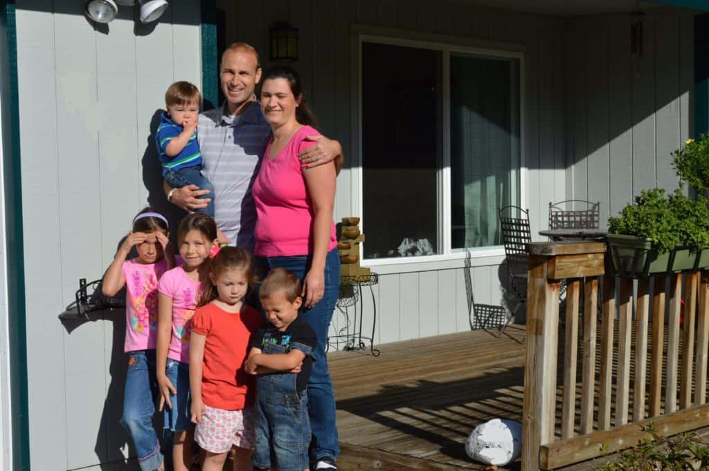 Family photo of 7 people standing on the front porch.