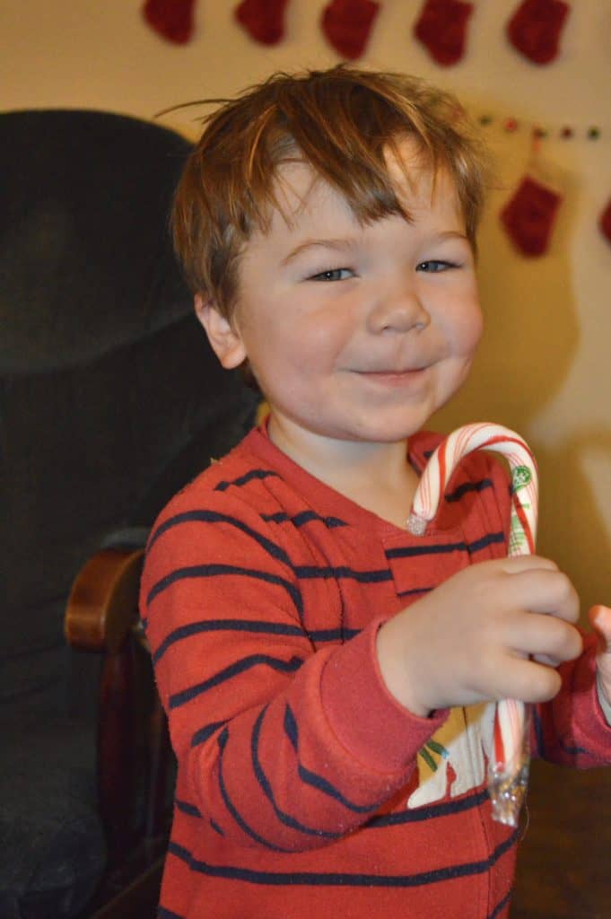 boy in pajamas with candy cane