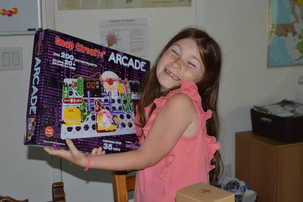 girl holding Snap Circuits Arcade set