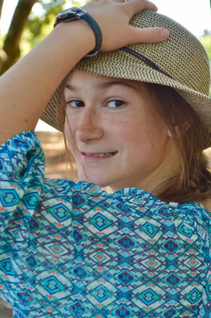 girl with straw hat and hand on head