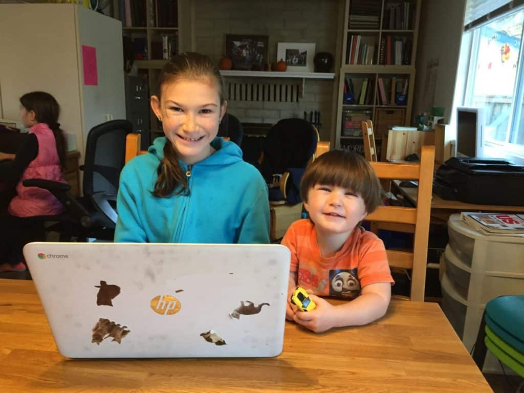 girl and boy at table working on laptop