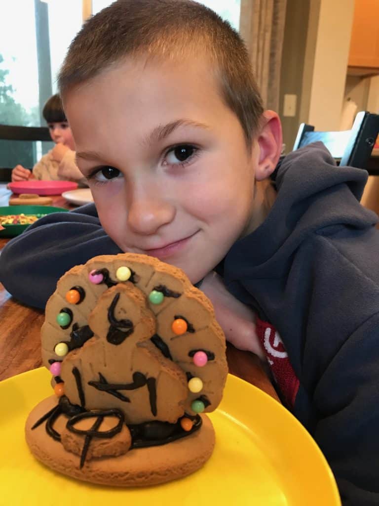 Boy with turkey gingerbread cookie on yellow plate. New traditions can help make grief during the holidays easier.