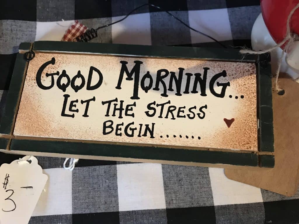 handpainted sign says good morning let the stress begin