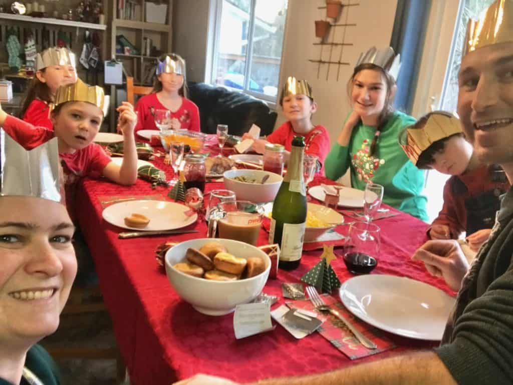 family with paper crowns on heads at Christmas table