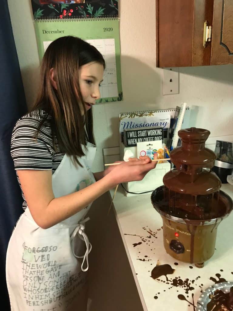 Girl enjoying chocolate fountain. Creating new traditions can help with grief during the holidays.