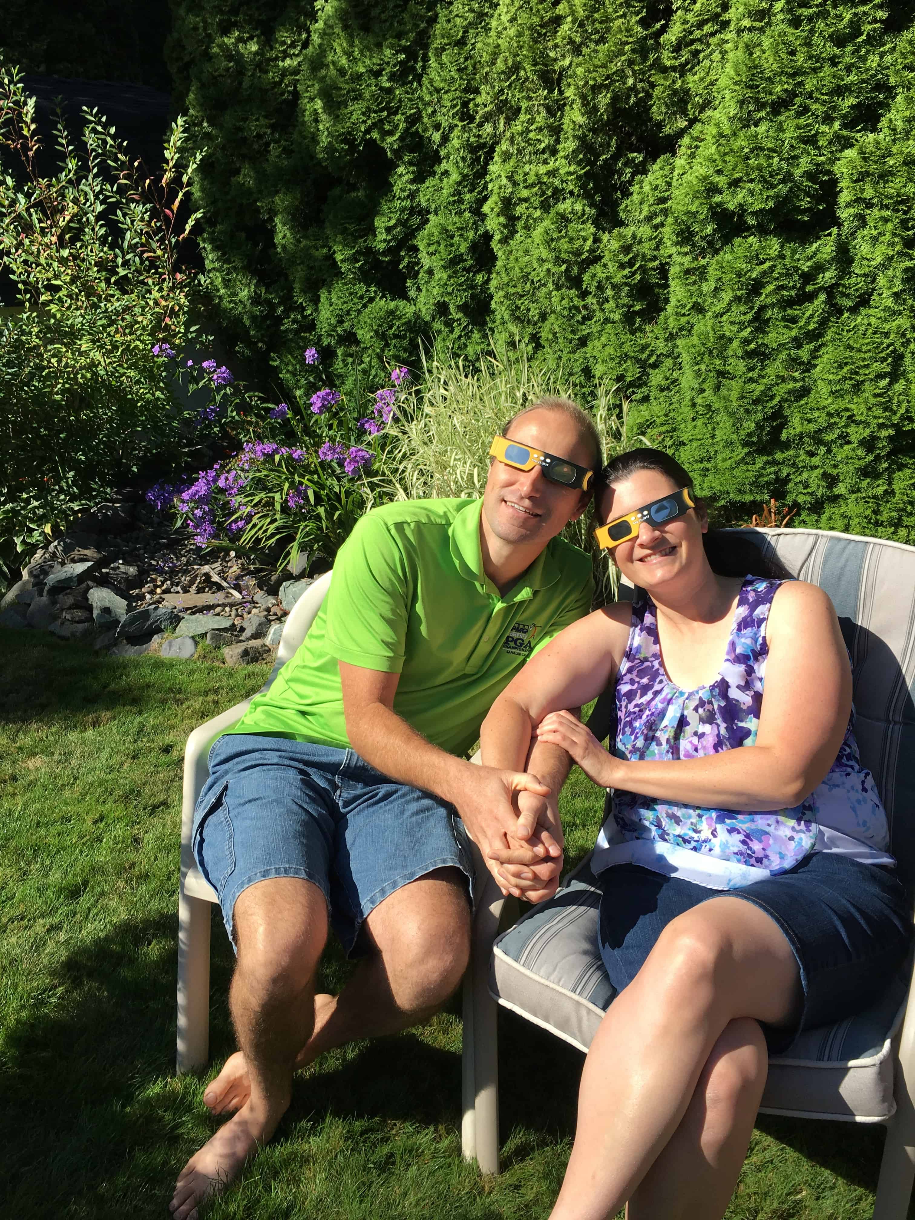 man and woman with eclipse glasses