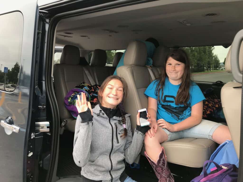 two girls inside van smiling