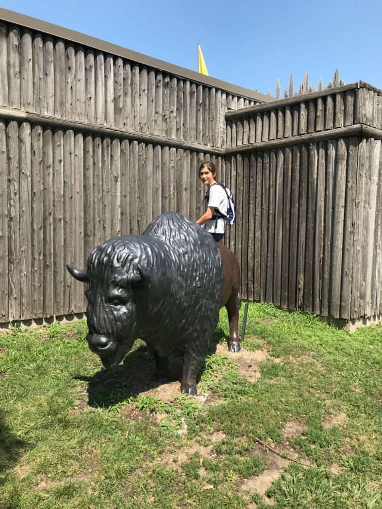 Girl on bronze buffalo at Fort Cody backyard