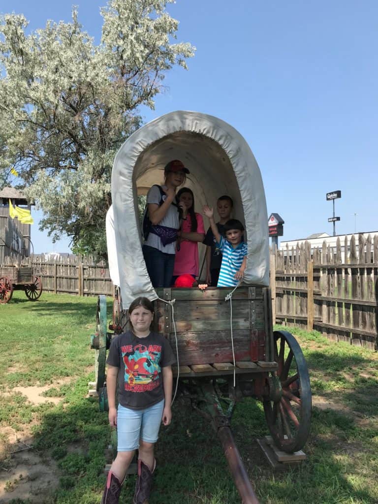 Kids inside of covered wagon at Fort Cody