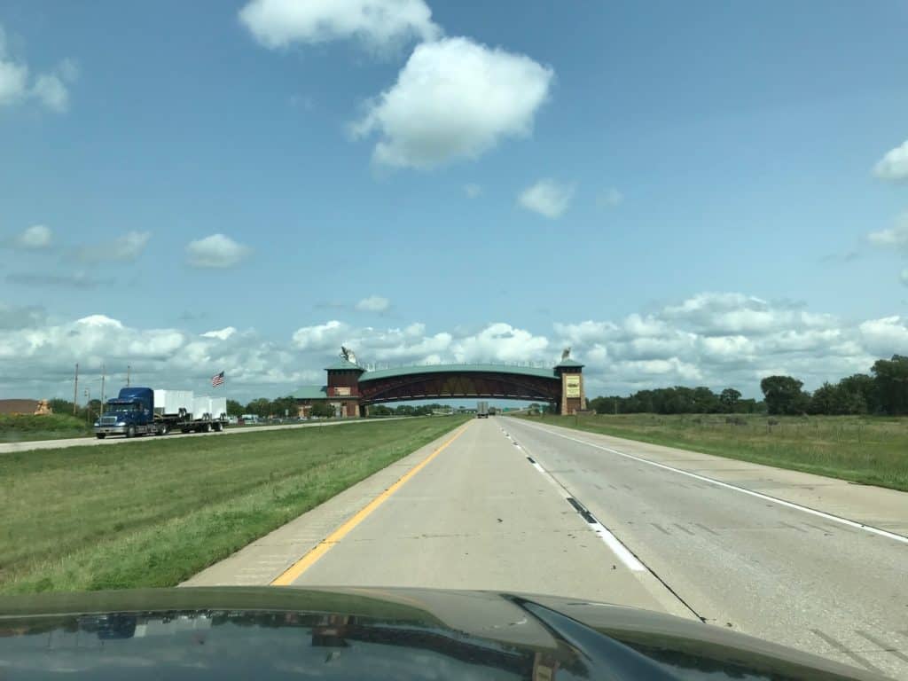 bridge over highway in Kansas as seen from vehicle.