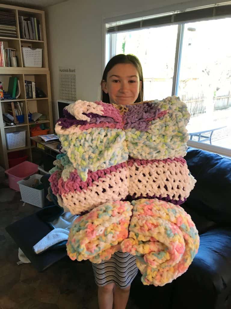 Girl holding crocheted blankets