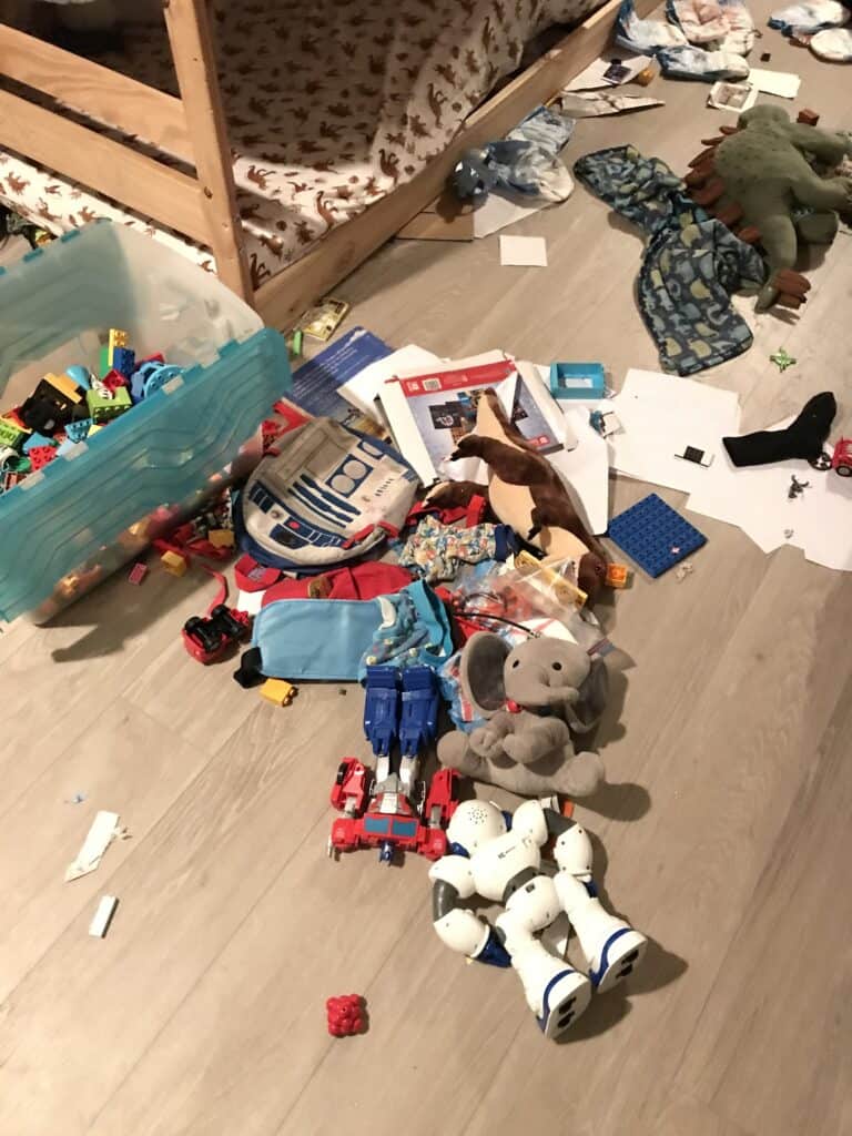 one of our children's bedrooms with toys, clothes, art supplies and more all over the floor