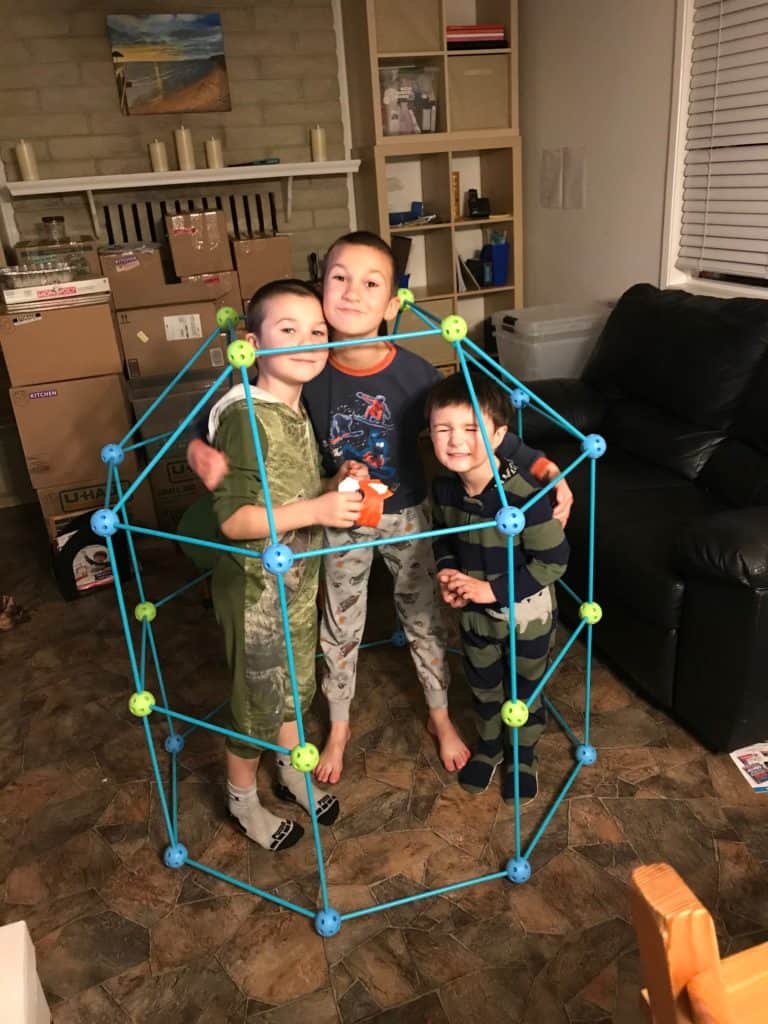 fort building frame with three boys inside. Easy activities to do with kids.