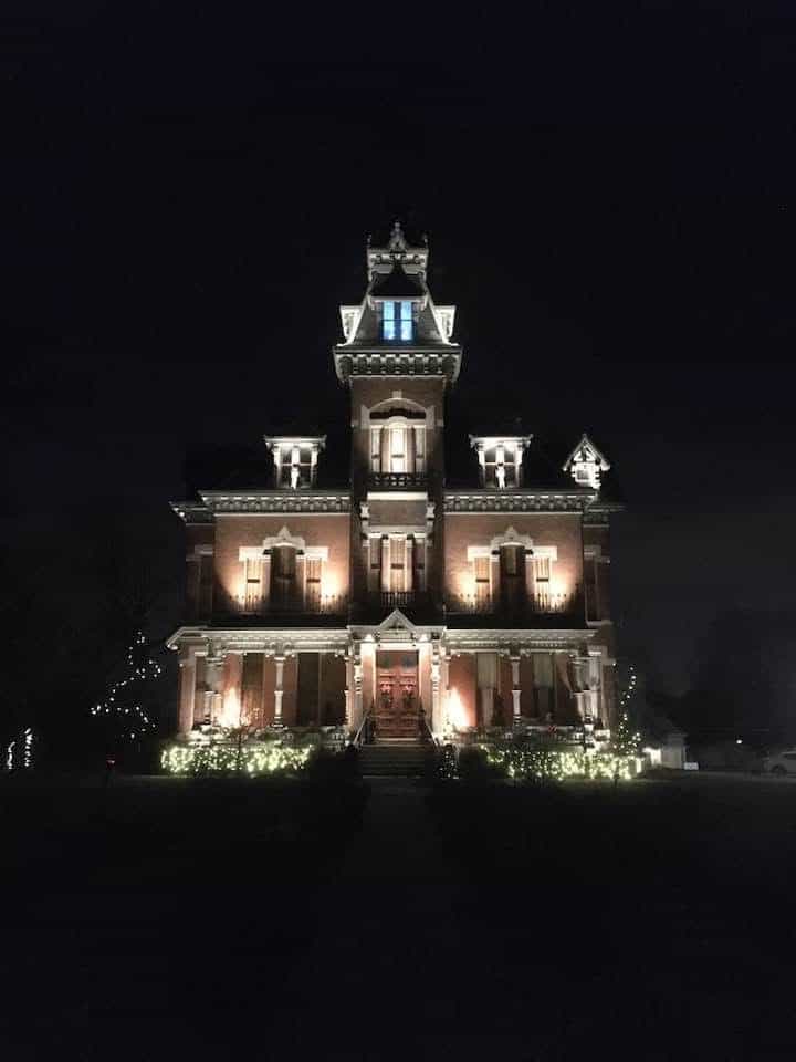 The grand Vaile Mansion is lit at night and decorated for the holidays. This impressive building is a remarkable example of Victorian architecture.