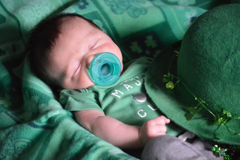 baby with green binky on st Patricks day green blanket