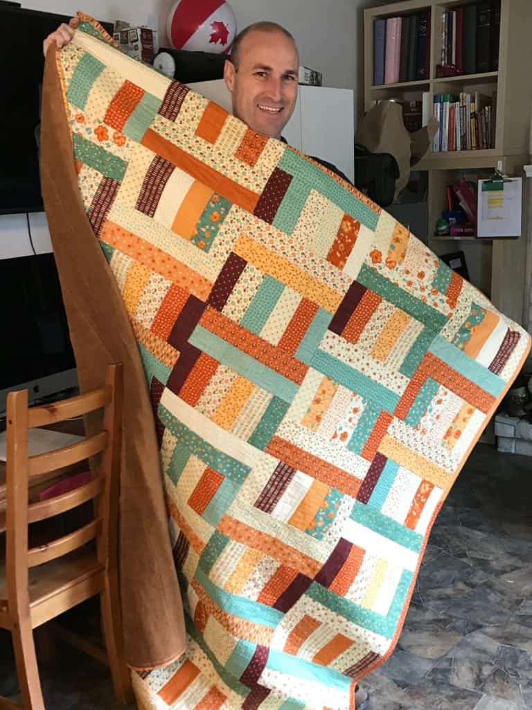 Man holding quilt. 