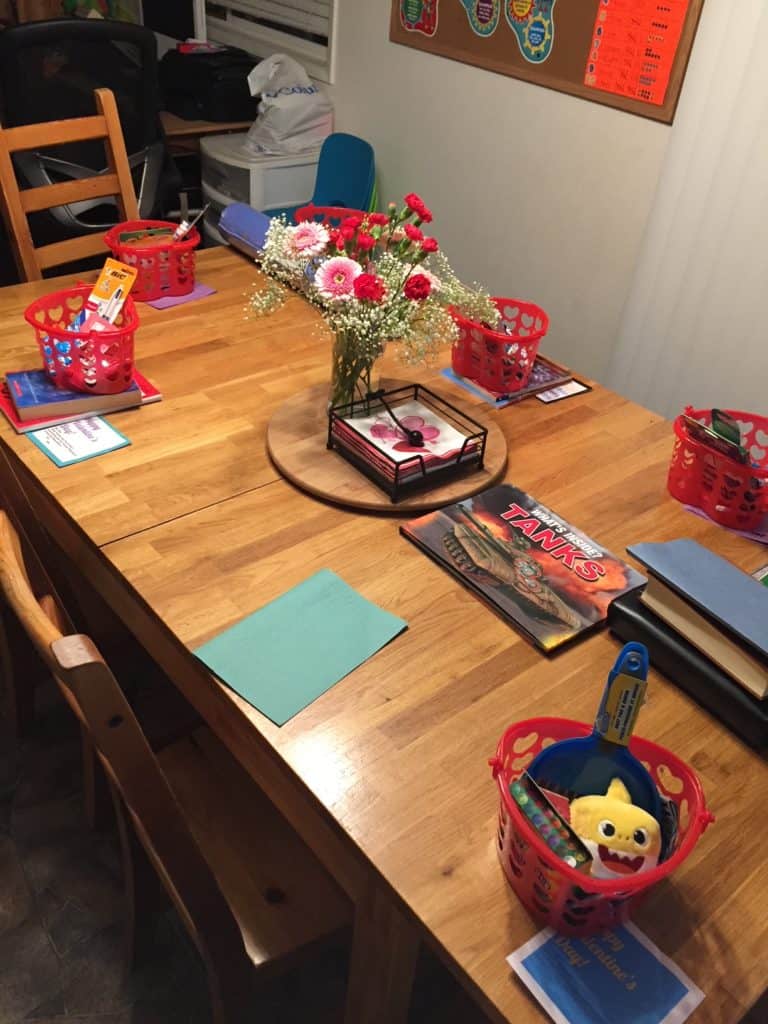 Heart baskets with gifts on table for Valentine's Day.