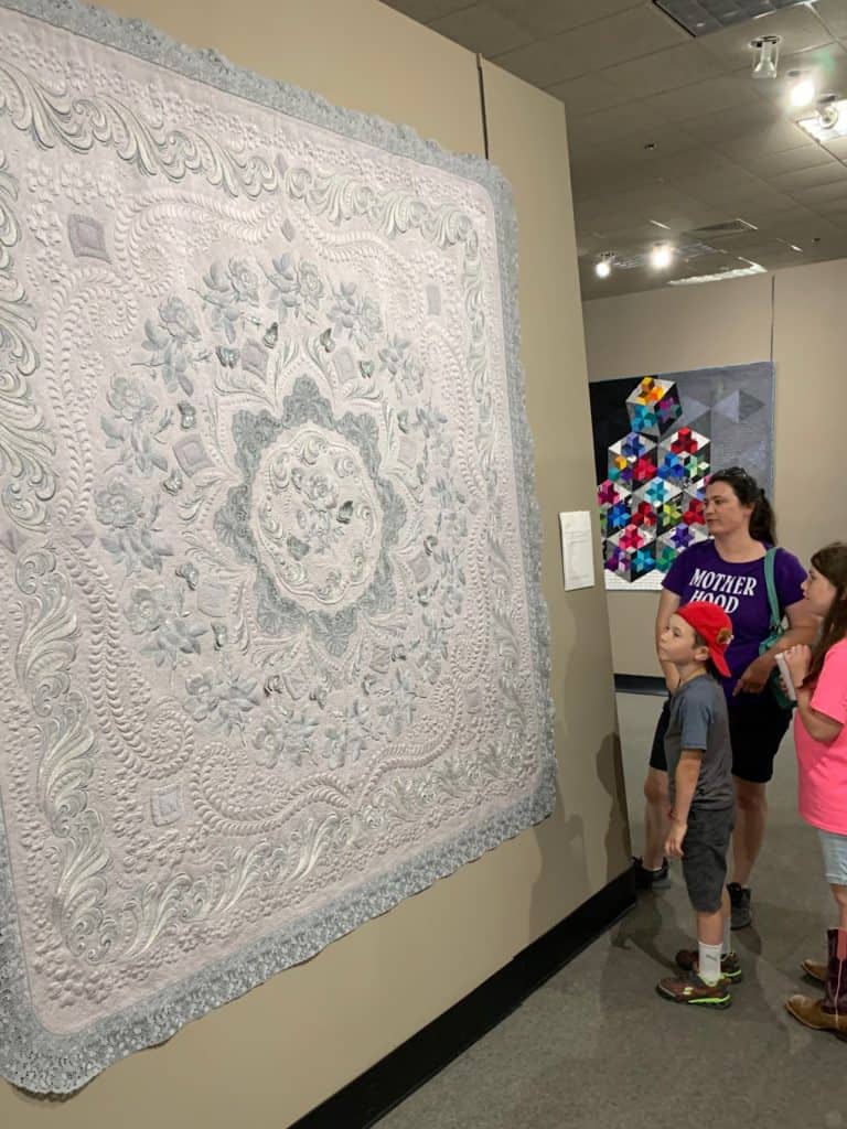 Huge silver and gray quilt with people admiring it at the National Quilt Museum in Paducah, Kentucky.