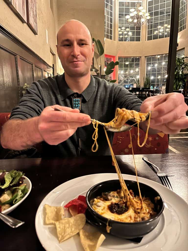 Man eating queso fundido.