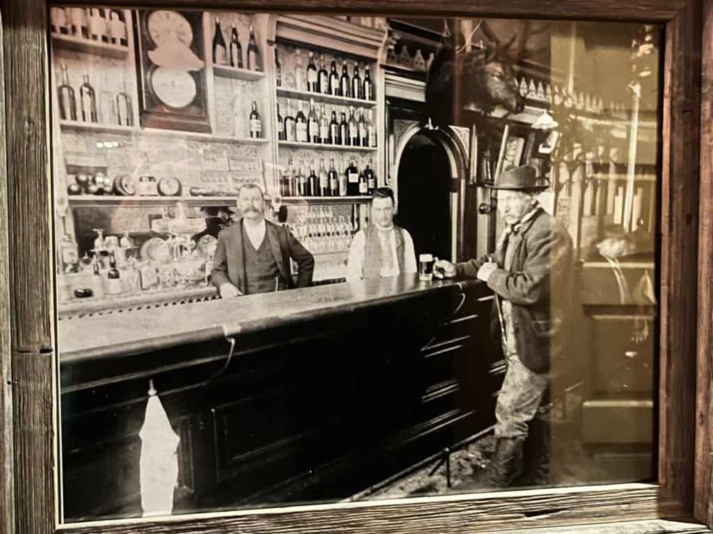 Black and white photo of men at a bar in the original Markum Inn building.