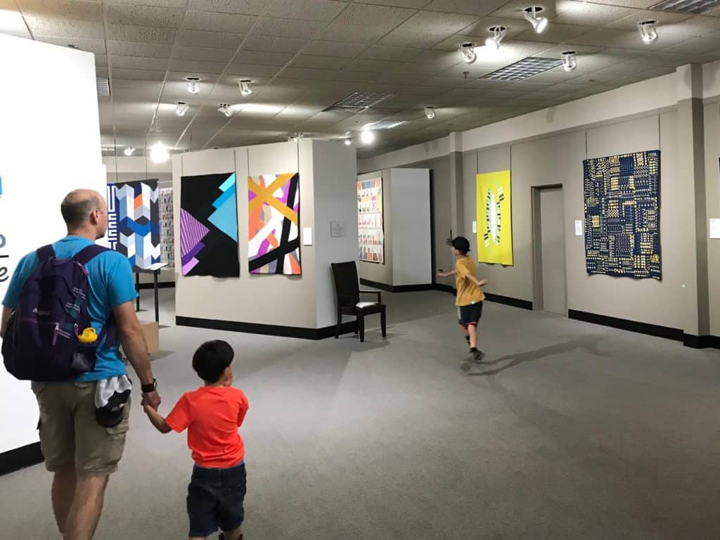 National Quilt Museum gallery with children and adult exploring.