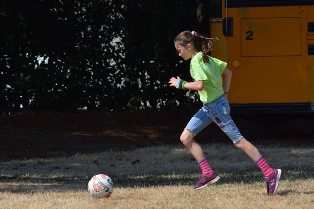 Girl chasing soccer ball. Soccer balls or basketballs are great active gifts for kids.