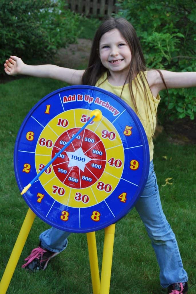 Girl behind archery target. Archery sets are some of the best active gifts for kids.