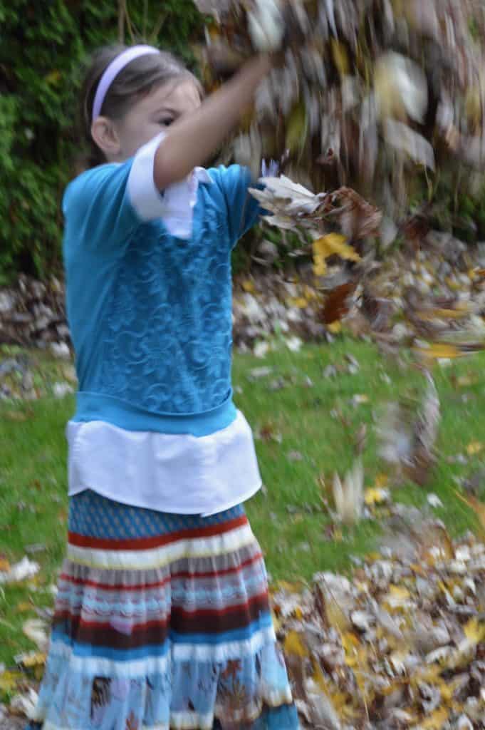 Girl tossing leaves in the air. Constant motion can be a symptom of ADHD in teen girls.