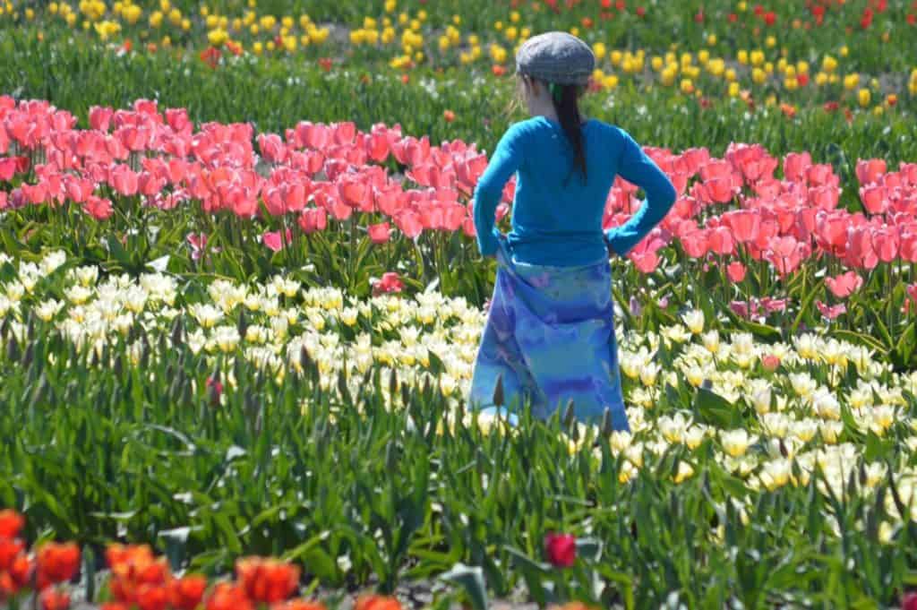 Girl walking through tulip fields. Girls with hyperactive ADHD type often struggle to keep still.