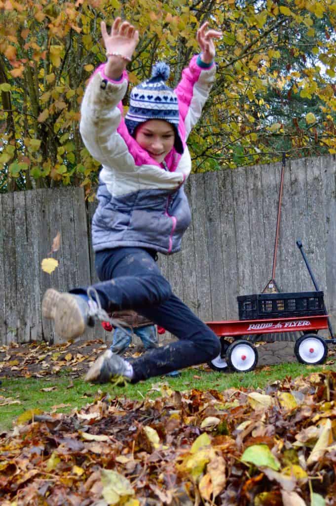Girl jumping into leaf pile. Impulsivity is a common sign of ADHD in teen girls.