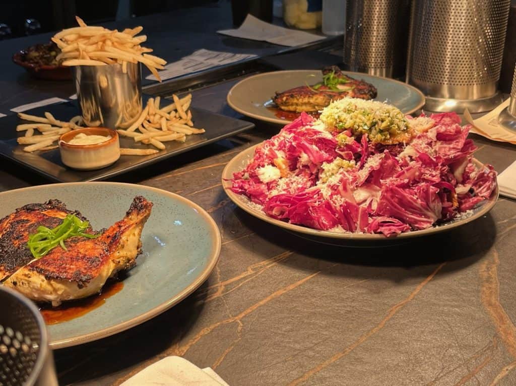 Moroccan brick chicken, fries with aioli. radicchio salad at the Cozy Taberna.