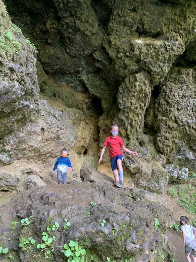 Boys climbing rocks behind the South Fall at Silver Falls.
