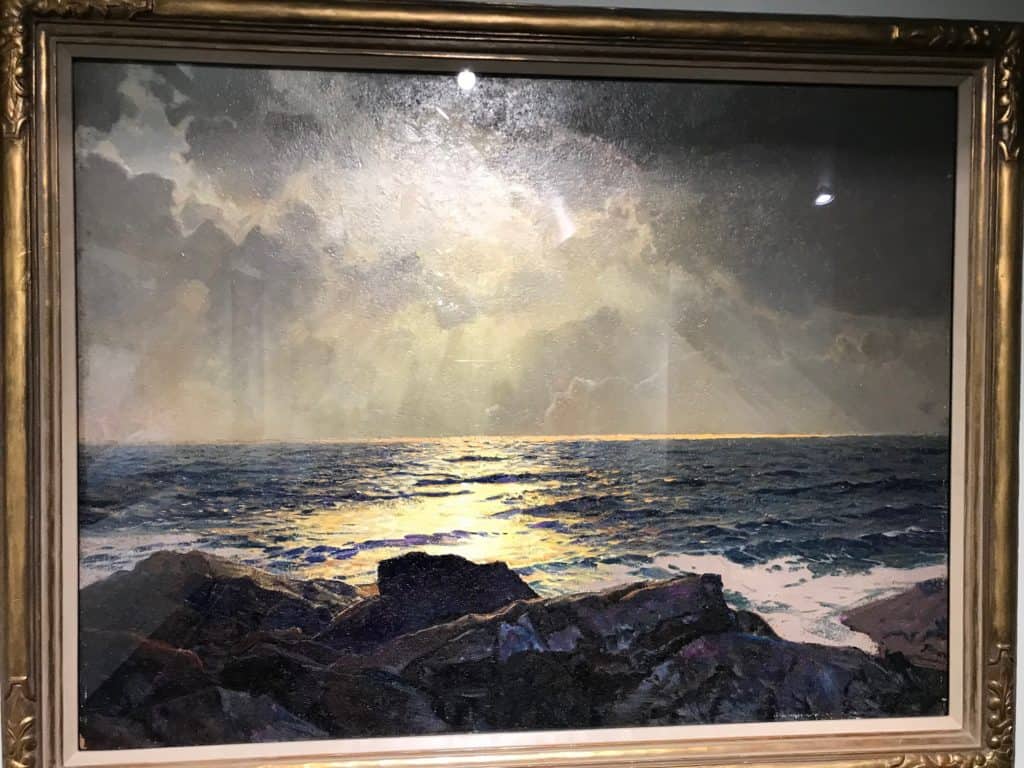 Painting on display at the Nashville Parthenon. Painting depicts a coastal scene with the sun breaking through clouds.