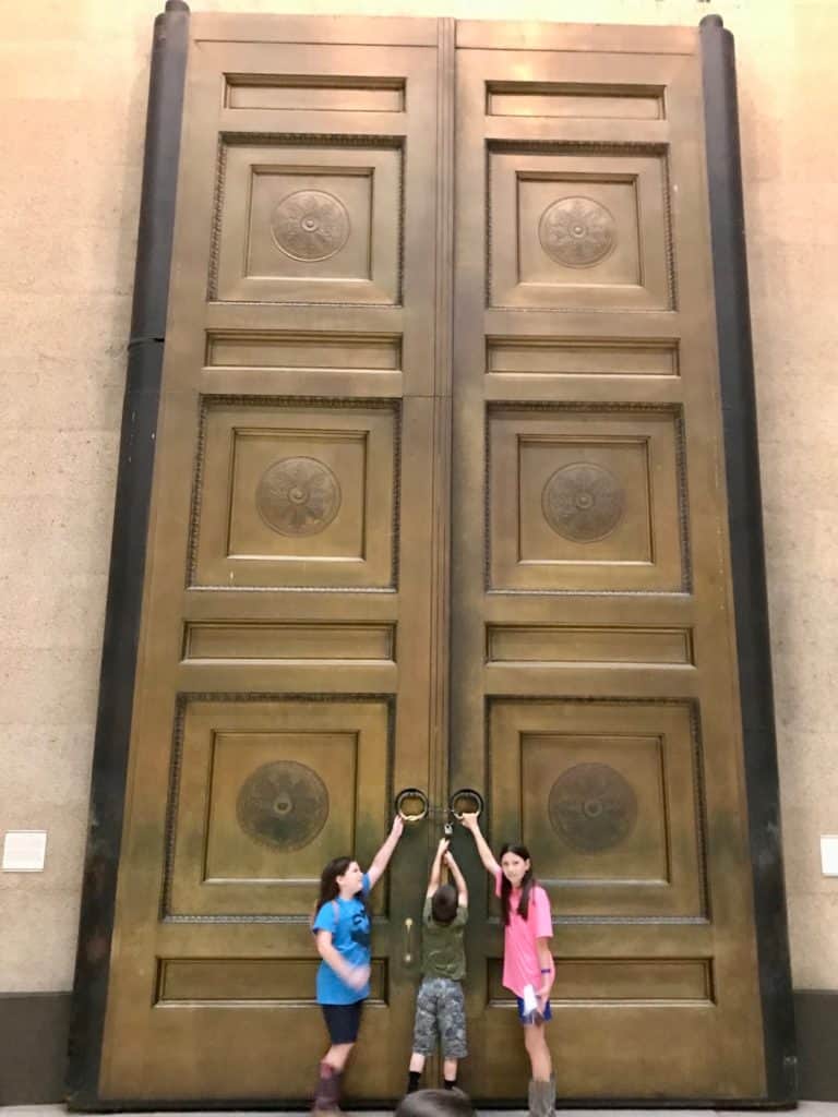 Kids in front of gigantic doors at the Nashville Parthenon.