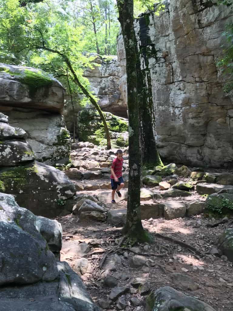 Boy running amongst boulders at Moss Rock.