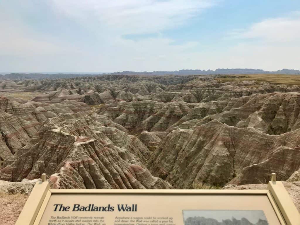 Badlands Wall sign and Badlands hills in background.